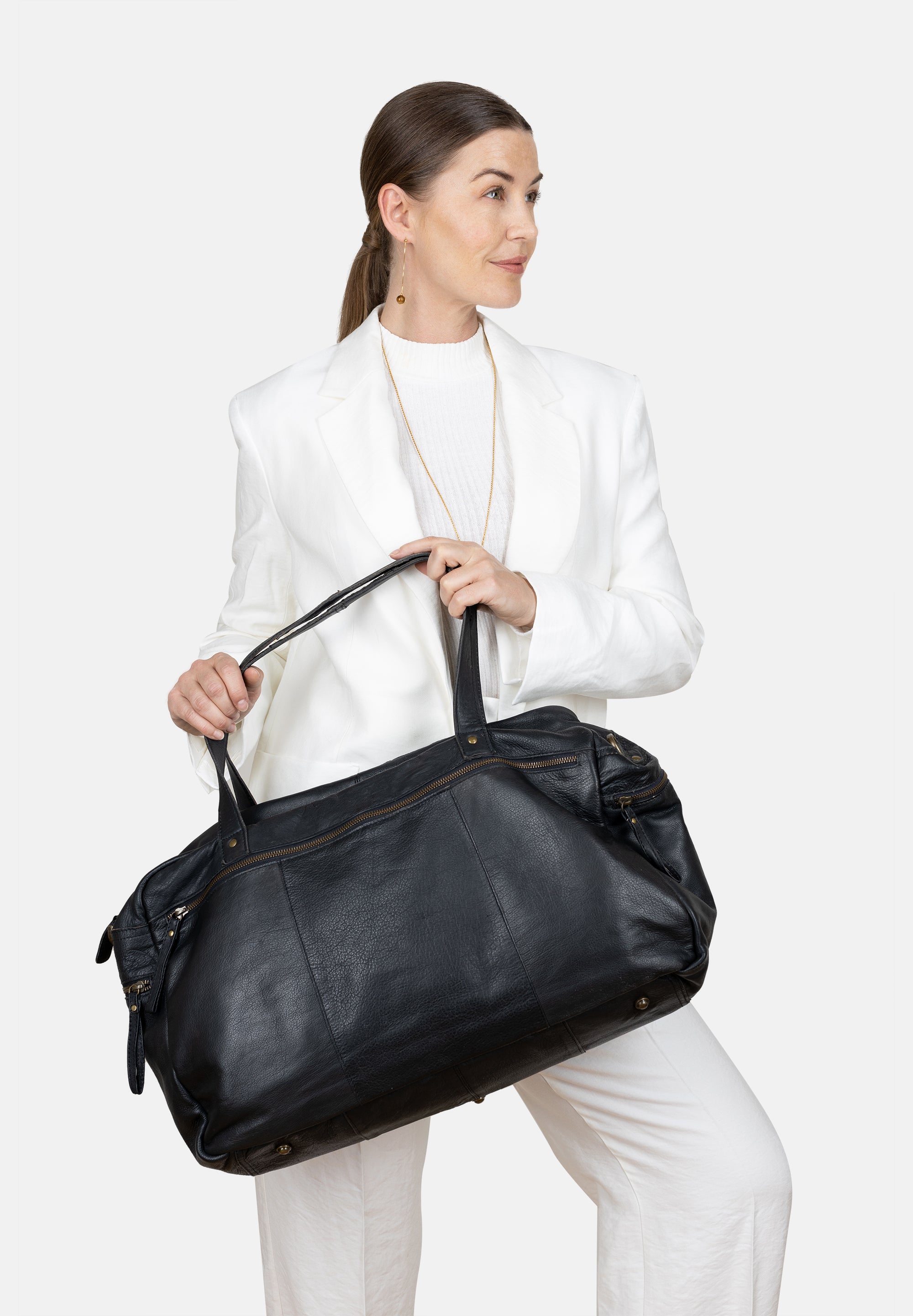 Dame som holder sort weekend bag av mykt skinn fra Re:Designed by Dixie, modell Signe.